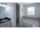 Bathroom featuring a built-in bathtub, window, and vanity with a countertop at 5095 Southlawn Ave, Orlando, FL 32811