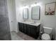 Bathroom with double vanity, framed mirrors, and decorative wall art at 5095 Southlawn Ave, Orlando, FL 32811