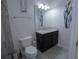 Bathroom featuring a toilet, dark vanity with light countertop and a mirror at 5095 Southlawn Ave, Orlando, FL 32811