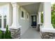 Welcoming front porch featuring stone pillars and a blue front door at 5095 Southlawn Ave, Orlando, FL 32811