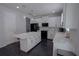 Modern kitchen features sleek white cabinets, quartz countertops, a center island and black appliances at 5095 Southlawn Ave, Orlando, FL 32811