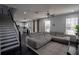 Open-concept living room featuring a gray sofa and a staircase at 5095 Southlawn Ave, Orlando, FL 32811