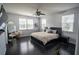 Spacious main bedroom featuring hardwood floors, multiple windows, and a modern ceiling fan at 5095 Southlawn Ave, Orlando, FL 32811
