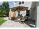 Comfortable outdoor patio featuring wicker seating, a glass table, privacy screening, and an umbrella for shade at 5095 Southlawn Ave, Orlando, FL 32811