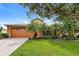 Charming home featuring a well-manicured lawn, mature landscaping, and a welcoming front entrance at 154 Indian Wells Ave, Kissimmee, FL 34759