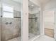 Modern bathroom features a tile shower with glass enclosure, and separate tiled space with wall mounted controls at 1553 Amber Leaf Cir, Ocoee, FL 34761