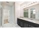 Bathroom with double vanity sinks, granite counters, dark cabinets and walk in shower at 1553 Amber Leaf Cir, Ocoee, FL 34761