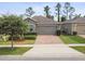 Well-maintained one-story home with brick driveway, stone accents, and a two-car garage at 1553 Amber Leaf Cir, Ocoee, FL 34761
