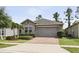 Charming single-story home with stone accents, lush landscaping, and a two-car garage at 1553 Amber Leaf Cir, Ocoee, FL 34761