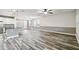 Spacious living room with wood-look floors, modern lighting, and an open layout to the kitchen at 1553 Amber Leaf Cir, Ocoee, FL 34761