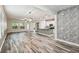 Open-concept living area with wood floors and a stone accent wall, flowing into kitchen at 1553 Amber Leaf Cir, Ocoee, FL 34761