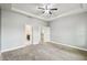 Spacious main bedroom with tray ceiling, neutral carpet and paint, and ensuite bathroom access at 1553 Amber Leaf Cir, Ocoee, FL 34761