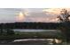 Scenic pond view at sunset offers a peaceful natural setting at 1553 Amber Leaf Cir, Ocoee, FL 34761