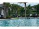 Resort-style community pool with ample seating and palm trees at 1553 Amber Leaf Cir, Ocoee, FL 34761