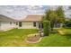 A well-maintained backyard with lush green grass, landscaping, and the home's exterior featuring siding and windows at 17567 Se 81St Parnassus Ct, The Villages, FL 32162