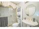 Bathroom featuring a sink, toilet, and shower with decorative glass doors at 17567 Se 81St Parnassus Ct, The Villages, FL 32162