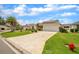 A single-story home with a manicured lawn, attractive landscaping, and a concrete driveway leading to an attached garage at 17567 Se 81St Parnassus Ct, The Villages, FL 32162