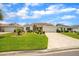 Charming single-story home with a well-manicured lawn, mature landscaping, and a paved driveway leading to a two-car garage at 17567 Se 81St Parnassus Ct, The Villages, FL 32162