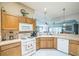 Bright kitchen featuring wooden cabinets, tile backsplash, and modern appliances with an open view to the living room at 17567 Se 81St Parnassus Ct, The Villages, FL 32162
