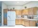 Spacious kitchen showcases ample wood cabinetry, a white refrigerator with water dispenser, and neutral countertops at 17567 Se 81St Parnassus Ct, The Villages, FL 32162