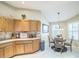 Bright kitchen with wooden cabinetry, tile backsplash, and a breakfast nook with a decorative chandelier at 17567 Se 81St Parnassus Ct, The Villages, FL 32162