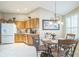 Kitchen nook with wooden cabinets, white refrigerator, and a decorative chandelier with natural light at 17567 Se 81St Parnassus Ct, The Villages, FL 32162