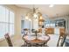 Kitchen nook with wooden table, chairs, decorative chandelier, and kitchen view, illuminated by natural light at 17567 Se 81St Parnassus Ct, The Villages, FL 32162