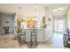 Kitchen view from the foyer with a breakfast bar featuring ornate bar stools and modern pendant lighting at 17567 Se 81St Parnassus Ct, The Villages, FL 32162