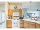 Well-lit kitchen with a gas range, wood cabinetry, and open access to living spaces at 17567 Se 81St Parnassus Ct, The Villages, FL 32162