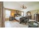 Large main bedroom with dark wood furniture, wood-look floors, ceiling fan, and natural light from windows at 17567 Se 81St Parnassus Ct, The Villages, FL 32162