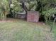 Lush backyard featuring a weathered shed, complemented by mature trees at 5418 Brownell St, Orlando, FL 32810