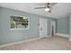 The spacious bedroom features wood-look flooring, a ceiling fan, and a bright window for natural light at 1304 E Myrtle St, Lakeland, FL 33801