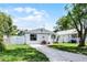 Beautiful home with white picket fence, green lawn and paved driveway at 1304 E Myrtle St, Lakeland, FL 33801