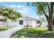 Charming single-story home with a well-manicured lawn and a white picket fence at 1304 E Myrtle St, Lakeland, FL 33801