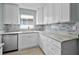 Modern kitchen featuring white cabinets, granite countertops, and stainless steel appliances at 1304 E Myrtle St, Lakeland, FL 33801