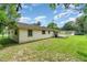 Large backyard featuring lush greenery, a covered patio, and a serene outdoor space at 201 W New York Ave, Orange City, FL 32763