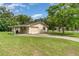 Side view of home with garage and covered parking, surrounded by green lawn at 201 W New York Ave, Orange City, FL 32763