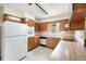 Cozy kitchen showcasing wood cabinetry, neutral countertops, and standard appliances at 201 W New York Ave, Orange City, FL 32763