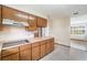 Kitchen with light countertops and wood cabinets open to another living space at 201 W New York Ave, Orange City, FL 32763