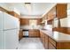 Traditional kitchen with wood cabinets, neutral countertops, and white appliances at 201 W New York Ave, Orange City, FL 32763
