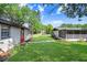 Backyard featuring the home's exterior, lush lawn, and convenient walkway at 223 Pinehurst Dr, Auburndale, FL 33823
