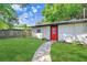 Landscaped backyard with a well-maintained lawn and a charming pathway leading to the house at 223 Pinehurst Dr, Auburndale, FL 33823
