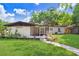 Well-maintained backyard with a screened-in porch and a stone pathway winding through the green lawn at 223 Pinehurst Dr, Auburndale, FL 33823