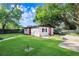 Expansive backyard showcasing the home, verdant lawn, and manicured landscaping at 223 Pinehurst Dr, Auburndale, FL 33823