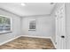 Neutral bedroom with wood-look flooring and a pair of windows at 223 Pinehurst Dr, Auburndale, FL 33823