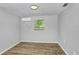 This simple bedroom features light gray walls, new floors and a modern light at 223 Pinehurst Dr, Auburndale, FL 33823