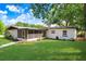 Well-maintained home exterior featuring a lush green lawn and mature trees at 223 Pinehurst Dr, Auburndale, FL 33823