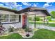 Close-up of the front entrance, showcasing a modern red door and decorative rain chains at 223 Pinehurst Dr, Auburndale, FL 33823