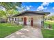 Exterior view of a renovated house, showing the front door and covered car port at 223 Pinehurst Dr, Auburndale, FL 33823