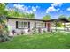 A cozy single-story home featuring a vibrant green lawn, complemented by landscaped flower beds at 223 Pinehurst Dr, Auburndale, FL 33823